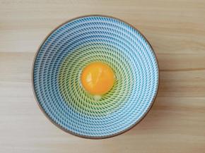 鸡蛋嗑入碗里。