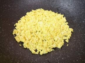 炒锅内继续倒入食用油，鸡蛋打散，倒入蛋液滑炒成型，用铲子敲碎。