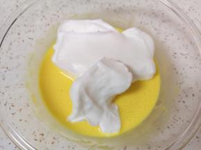 打发好的蛋白分成三份，取中间的三分之一加入到蛋黄糊里面，用硅胶刮刀采用切拌和翻拌的方法混合均匀。