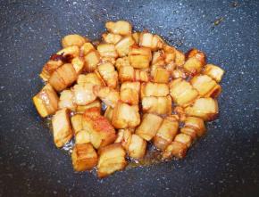 下入五花肉，大火翻炒3分钟左右，肉的颜色明显变深。