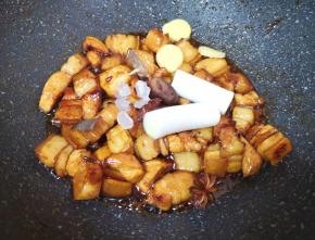 加入料酒，翻炒至料酒挥发掉一半，加入冰糖、葱姜香料炒香。