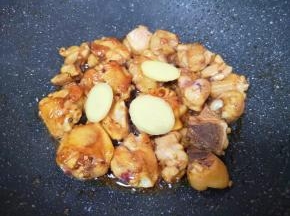 下入鸡块大火爆炒，将鸡肉的水分炒出来，让鸡皮上色，放姜片和料酒翻炒均匀。