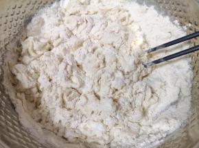 面粉中加入盐和水，先用筷子搅成絮状。