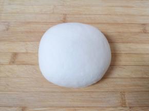 絮状的面粉倒在案板上，揉成光滑的面团。