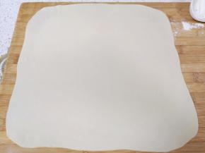 取一份面团擀成接近正方形的大面片。