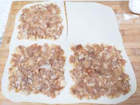 将面片分成四份，正上方的中间用刀划开，右上角的一份空出来，剩下的三分均匀的抹上肉馅，每一份的中间空出来一公分（如图）。