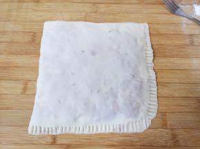 最后将上面的面片折下来，压在下面面片上（如图），用叉子压紧边缘，肉饼完成。