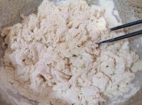 将酵母水加入面粉中，先用筷子搅拌成絮状。