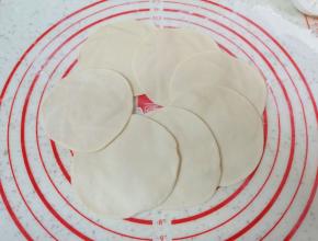 擀成中间稍厚边缘薄的包子皮。