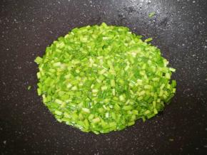 炒锅内继续倒油烧热，下入蒜苗碎炒香。