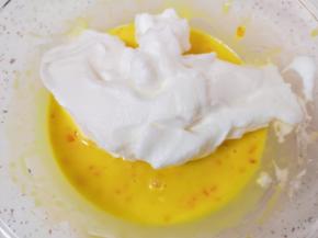 打发好的蛋白分成三份，取中间的三分之一加入到蛋黄糊里面，用硅胶刮刀采用切拌和翻拌的方法混合均匀。