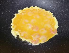 炒锅内倒适量的食用油烧热，倒入虾仁蛋液。