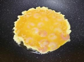 炒锅内倒适量的食用油烧热，倒入虾仁蛋液。