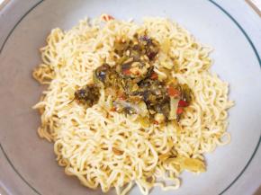 先将煮好的面条捞在碗里，放上酸菜。