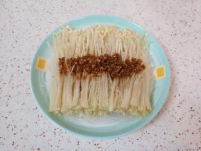 将炒好的蒜末汤汁浇在金针菇上面。