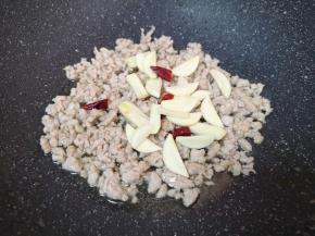 下入蒜片和干红辣椒炒香。