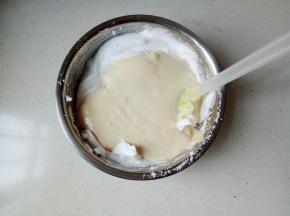 将搅拌均匀的蛋糕糊加入蛋白霜中，翻拌均匀