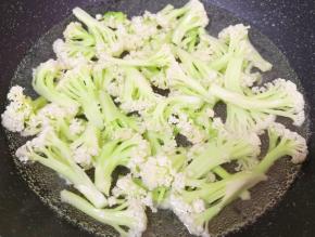 锅里放水烧开，下入清洗干净的有机菜花焯水至变色，捞出控一下水分。