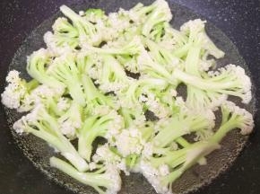 锅里放水烧开，下入清洗干净的有机菜花焯水至变色，捞出控一下水分。