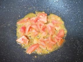 炒锅内倒适量的食用油烧热，下入西红柿翻炒至出汁。