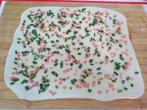 均匀的撒上火腿肠和葱叶碎，最后撒上盐。