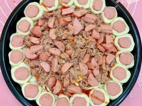 放一些马苏里拉芝士，再把香肠和金枪鱼铺上，撒点披萨草。
