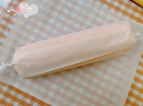 用擀面杖卷住油纸，顺势往上推，卷起来，两边跟拧糖一样拧起来。放入冰箱冷藏半小时后再切块食用。