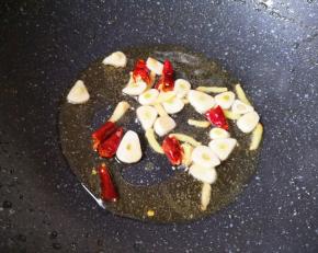 锅内重新倒入食用油烧热，下入蒜片姜丝和干红辣椒炒香。