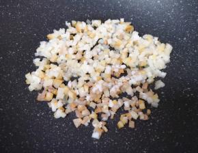 将切好的腊肉丁放入炒锅内，开小火不停的翻炒（切记锅内不放油）。