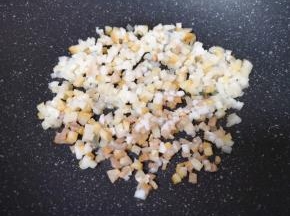 将切好的腊肉丁放入炒锅内，开小火不停的翻炒（切记锅内不放油）。