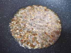 炒至腊肉的油脂流出，腊肉丁变至透明状。