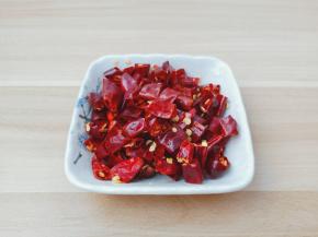 泡好的干辣椒用剪刀剪成小段。