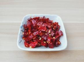 泡好的干辣椒用剪刀剪成小段。