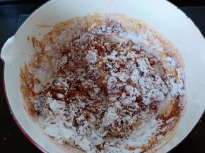 开小火倒入一半的木薯粉翻拌均匀。