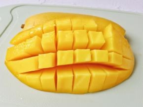 芒果对半切开，取一半的芒果划成颗粒状。