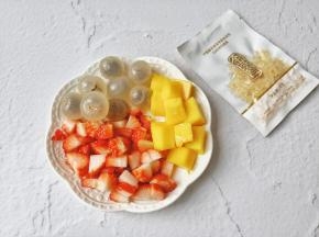 切好的水果粒放入盘中。