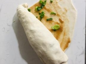 从饼的一侧卷起来，这样饼的层次就出来了！