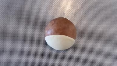 先做可可面团的小狗，取一点白色面团，擀成薄片盖在头下面。