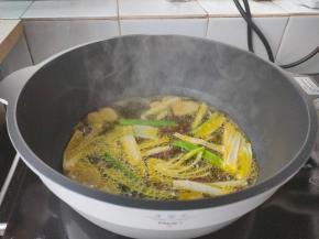 起锅加入一大勺植物油，下花椒、姜片、葱段炸香，当葱段呈褐色关火捞出姜片、葱段、花椒。