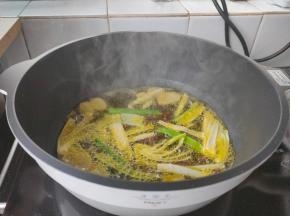 起锅加入一大勺植物油，下花椒、姜片、葱段炸香，当葱段呈褐色关火捞出姜片、葱段、花椒。