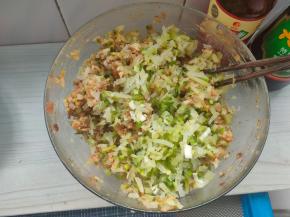 然后加入备好的萝卜丝，再撒上少许的盐，再次顺着一个方向搅打均匀。