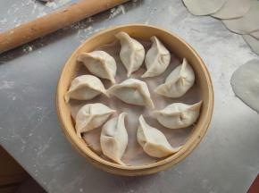 放上馅料，对折一挤，饺子就包好了，放入蒸格，饺子之间要留有空隙。
