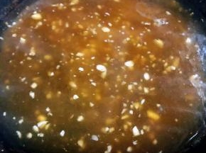 蒸肥牛金针菇卷的原汁原味汤汁倒入锅中再添加适量清水烧开放入蚝油、一品香酱油、糖开锅时倒入水淀粉搅拌成粘稠状最后撒上蒜粒即可