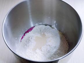 再加入高筋面粉，最后加入酵母粉，用旁边的面粉把酵母粉盖上，启动厨师机2档揉面一个程序。