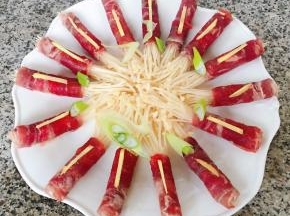 切好的葱姜摆在肥牛和金针菇上面