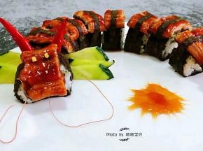 黄瓜摆在第一个寿司的后面上面插两个两个小红辣椒辣椒粒两个放在第一个鳗鱼片上做眼睛虾须子插在鳗鱼片下面就大功告成了