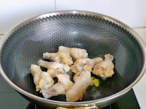 起油锅，加入姜片煸炒，再加入鸡翅根煎至微黄。