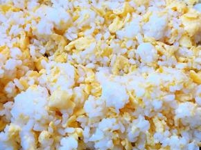 取一个鸡蛋打散锅中倒入油加热再倒入蛋液中火将鸡蛋炒至八分熟倒入米饭中火翻炒使米饭粒粒散开