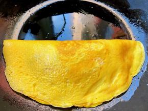 小心翼翼轻轻的将另一侧蛋皮包在时蔬炒饭上面即可出锅