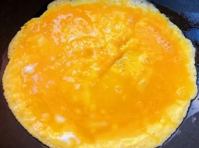 蛋饼基本成形再倒入剩余蛋液涂抹均匀继续中小火加热